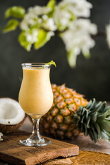 Pina colada pineapple cocktail or Lassi on a rustic wooden table