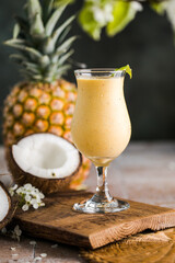 Pina colada pineapple cocktail or Lassi on a rustic wooden table