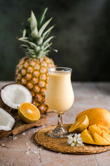 Pina colada pineapple cocktail or Lassi on a rustic wooden table - obrazy, fototapety, plakaty
