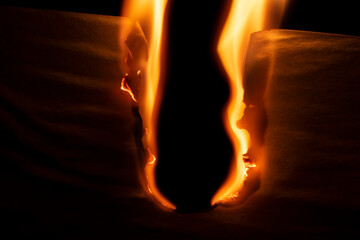 burning paper, glowing edge of paper on a black background