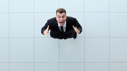 Celebrating success. Low angle view of excited young businessman keeping arms