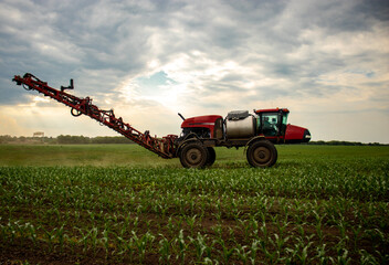 Red sprayer in a field of corn