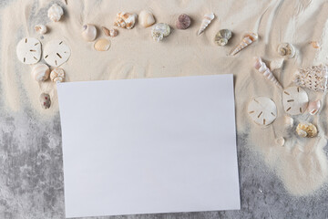 Card, sand and seashells on blue wooden planks, frame for summer advertisement	