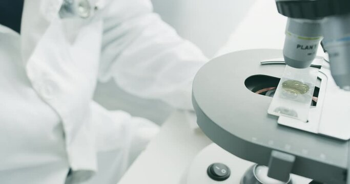 Microscope, scientist hands and blood sample for virus research for healthcare innovation. Medical, science and laboratory study in a hospital and clinic for pathology investigation for disease cure