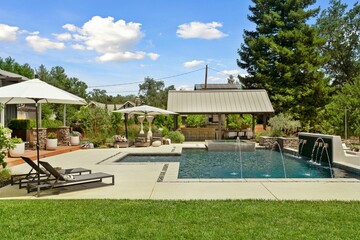 Obraz premium Swimming pool and Jacuzzi surrounded by fountains and backyard furniture 