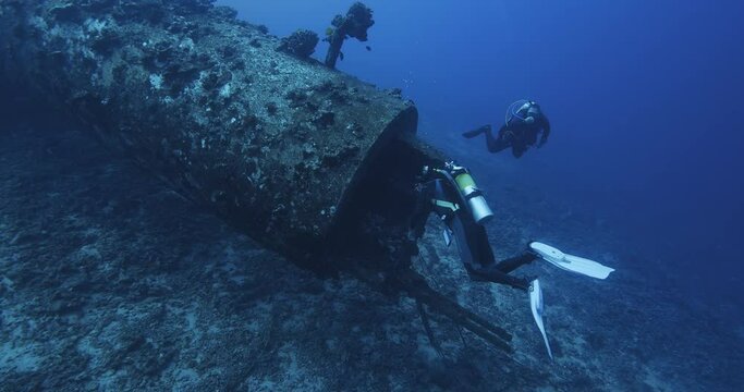  Scuba divers explore abandoned pipe.