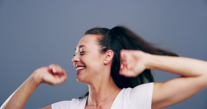 Happiness, dance and face of woman in studio isolated on a gray background. Dancing, smile and female person moving, freedom or celebration for good news, portrait or dancer having fun at music party