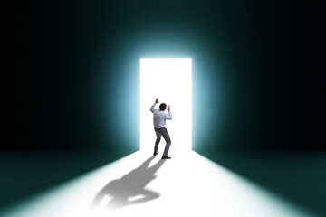 Businessman entering backlit door in escape concept