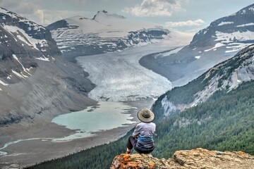 Woman on cliff over glacier lake in Canadian Rockies. Banff Natioanal park. Columbia Icefield....