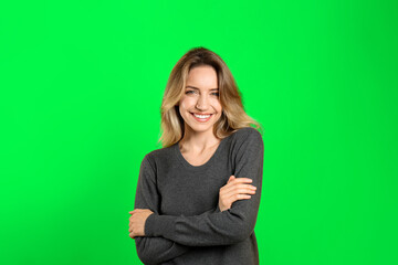 Chroma key compositing. Pretty young woman smiling against green screen