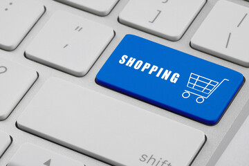 Online store purchase. Blue button with word Shopping and cart on laptop, closeup