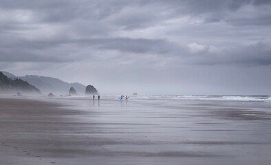 Surfers walking on beach in silhouette with colorful boards. Cannon Beach. Portland. Oregon. USA