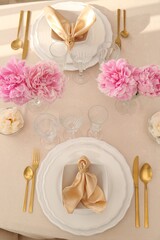 Stylish table setting with beautiful peonies and fabric napkins, above view