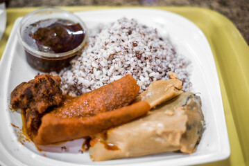 Local Ofada rice, beef, ponmo, and moi-moi are served in a restaurant.