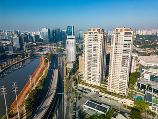 Obraz premium 2023 view of the Pinheiros river with modern buildings beside it and the famous Octavio Frias de Oliveira bridge in the city of São Paulo.