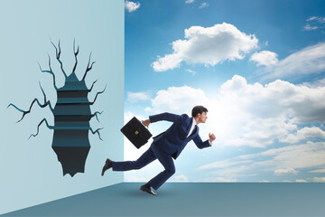 Businessman breaking through the wall