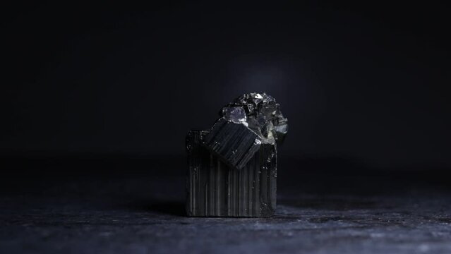 A pyrite mineral lit from above with a black background
