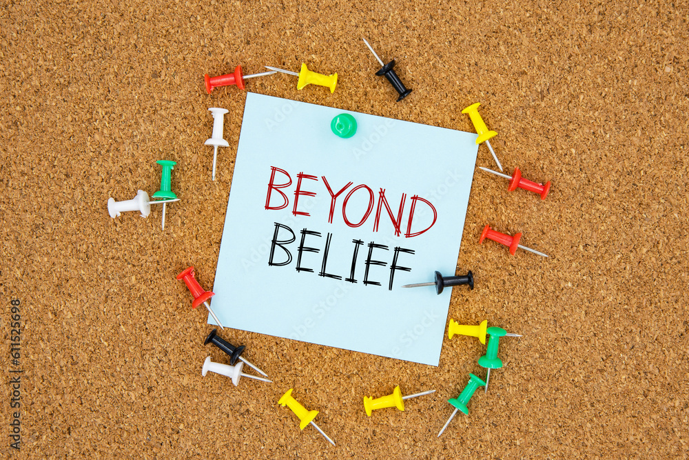 Poster beyond belief text on light blue post-it paper pinned on bulletin cork board surrounding by multi co