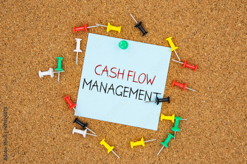 Poster cash flow management text on light blue post-it paper pinned on bulletin cork board surrounding by m
