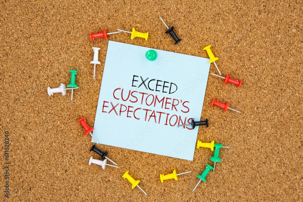 Poster exceed customer's expectations text on light blue post-it paper pinned on bulletin cork board surrou