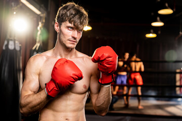 Boxing fighter shirtless posing, caucasian man boxer wearing red glove in defensive guard stance...