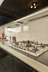 a modern kitchen with black counters and white backsplases on the stovetop in this image is taken...
