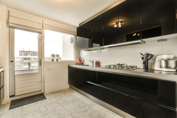 a kitchen with black cabinets and white marble counter tops on the counters in this photo is taken from the inside