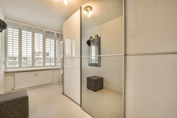 a very clean white room with lots of light coming in through the window panes on the wall and floor