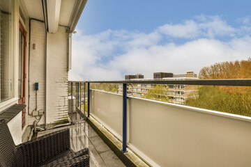 a balcony with some chairs and trees in the background on a sunny day, as seen from an apartment window