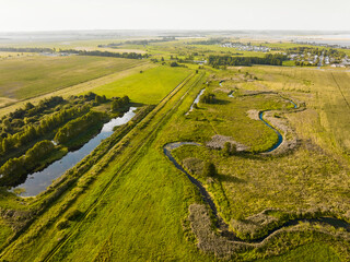 Small river and irrigation canals among countryside fields