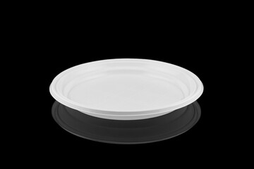 Disposable white plastic plate isolated on black background
