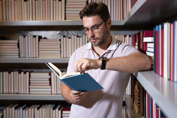 Portrait of professor with book in classroom. Handsome professor in library. Teachers Day. Good...