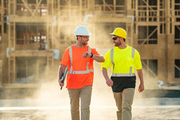 Two builders in a hard hat is busy working on a construction project at a site. A builders workes...