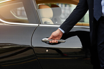 Businessman, hands and chauffeur by car door for travel accommodation, designated driver or...