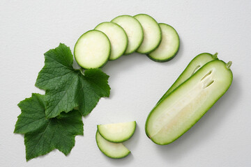 Against the white background, slices of winter melon (also known as ash gourd) and green leaves decorated. Winter melon contains a high content of vitamin B2 helps to reduce the risk of eye disorders.