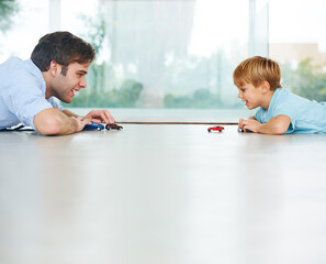 Playing, happy and a father and child with cars for bonding, quality time and happiness. Smile, family and a dad with a boy kid and toys for a race or competition on the floor of a house together