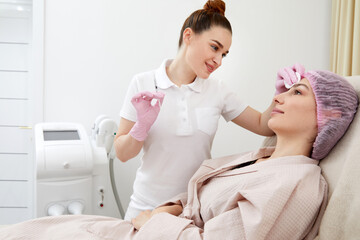 Obraz na płótnie Canvas Cosmetologist performs the lift procedure by injecting beauty injections. Doctor injecting hyaluronic acid as facial rejuvenation treatment