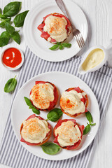 Eggs Benedict on white plate, top view