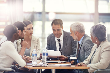 Planning, talking and business people with a report in a meeting for financial strategy or investment. Teamwork, diversity and employees in accounting with paper for results on investing or economy