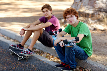 Happy, skateboarding and portrait of friends in the street for sports, hobby and recreation. Nature, happiness and kids with a skateboard in a park or neighborhood road for skating and weekend fun © Kimberly Hale/peopleimages.com