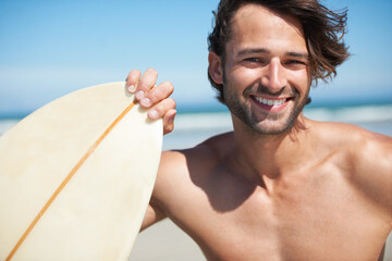 Portrait, surfboard and a man in the sea at the beach for surfing while on summer holiday or vacation. Face, smile and sports with a happy young male surfer shirtless outdoor by the ocean for a surf - Powered by Adobe