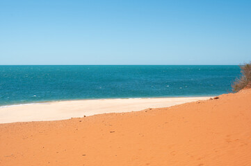 Sand Dune next to the ocean. Orange sand. Ocean. 