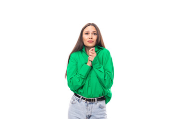 modest well-groomed brunette long-haired young woman in a green shirt on a white background with copy space