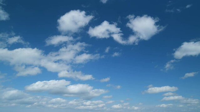 Blue sky background with tiny stratocumulus and cumulus fluffy clouds. Concepts of weather forecast, vacations. Timelapse.