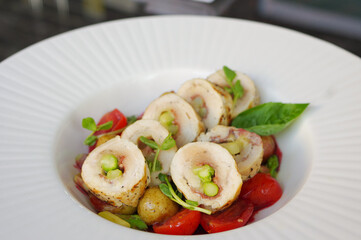 colorful sliced asparagus stuffed chicken breast roll with cherry tomatoes and grilled potatoes