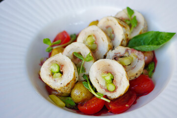 sliced asparagus stuffed grilled chicken breast roll with sprout, cherry tomatoes and potatoes