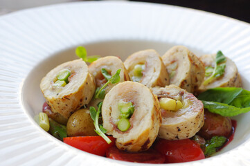 sliced asparagus stuffed grilled chicken breast roll with sprout, cherry tomatoes and potatoes