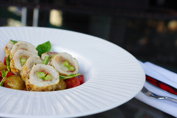 sliced asparagus stuffed chicken breast roll with cherry tomatoes and grilled potato