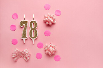 Number 78 on pastel pink background with festive decor. Happy birthday candles. The concept of celebrating a birthday, anniversary, important date, holiday. Copy space. banner