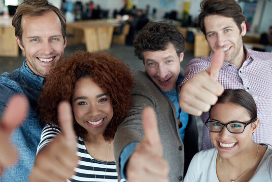 Portrait, thumbs up or business people smile in agreement, support or collaboration together in office. Startup community team, happy or group of employees with thumb up, yes or like hand gesture